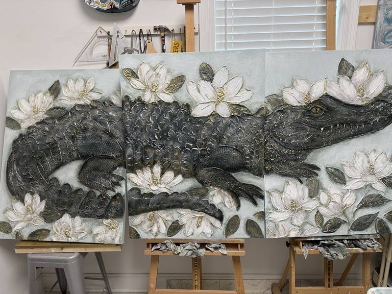 Artwork depicting an alligator surrounded by white flowers, showcasing a striking interplay of strength and delicate beauty.
